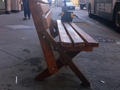 Close up of a bench leg frame with the bottom half of the front leg split-off, leading to an unsupported backrest.